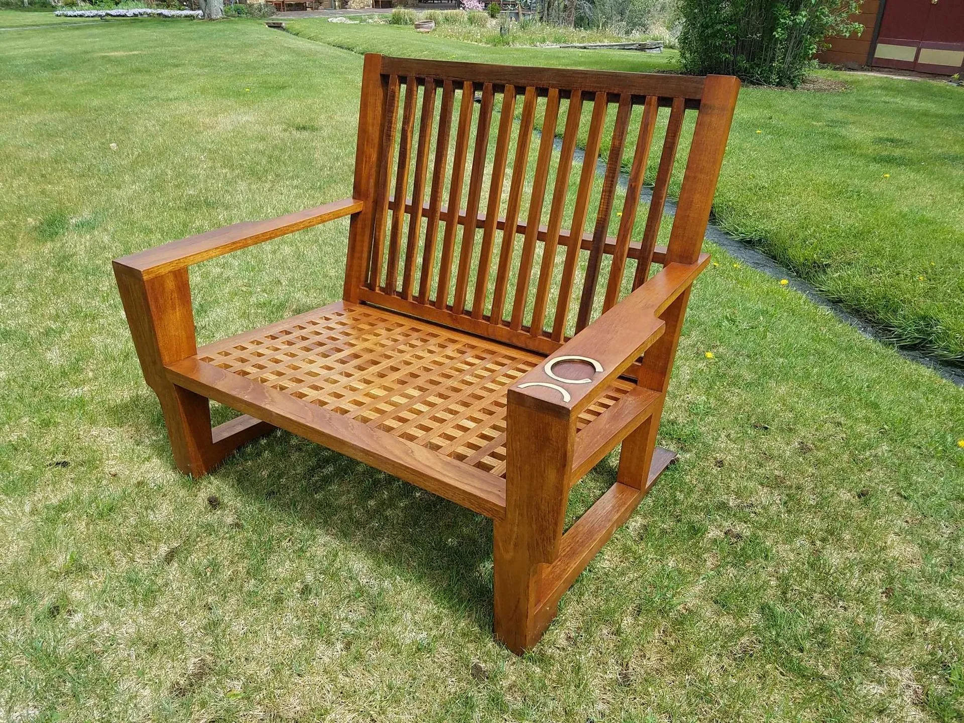 Wooden outdoor chair on a grassy lawn.