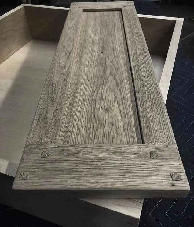 Assembled wooden cabinet door with frame and recessed panel. Light gray stain.